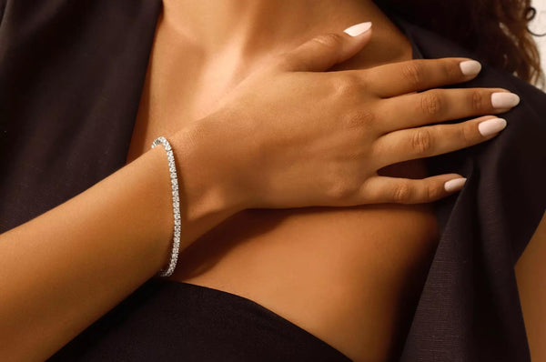 Are Tennis Bracelets in Style? Tennis Bracelet on a Hand with a Black Dress