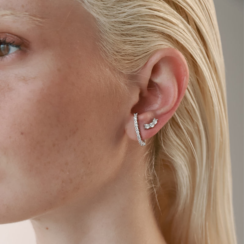 Model wearing the Comet's Trail Ear Stud made of sterling silver zirconia filled stud and a smaller three zirconia stud earrings.