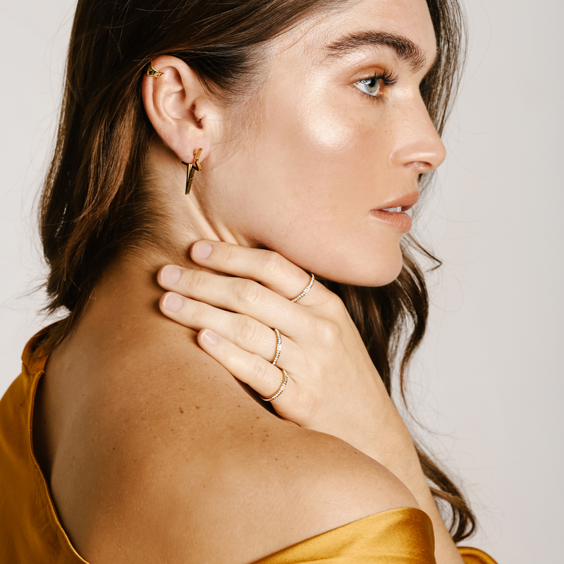 Model wearing the FLYING SOLO STARS EARRING comes in one piece of Gold plated star shaped earring. She is also wearing three gold Seeds rings that has Swarovski crystals around.