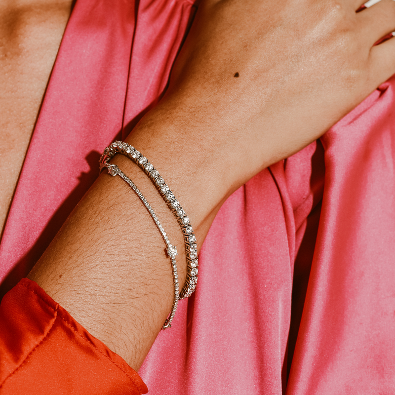 Model wearing the THIN TENNIS BRACELET which is made of 925 sterling silver and Cubic zirconia. It is filled with small zirconias and 3 Four Prongs zirconias that are 5.5mm each. She is wearing it together with the regular Tennis Bracelet.