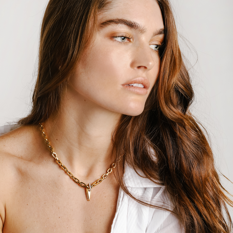Model wearing the bamboo necklace which is a 17 inches Gold chain necklace with 5 Triangle charms & Zirconia stacked together into a one charm. 