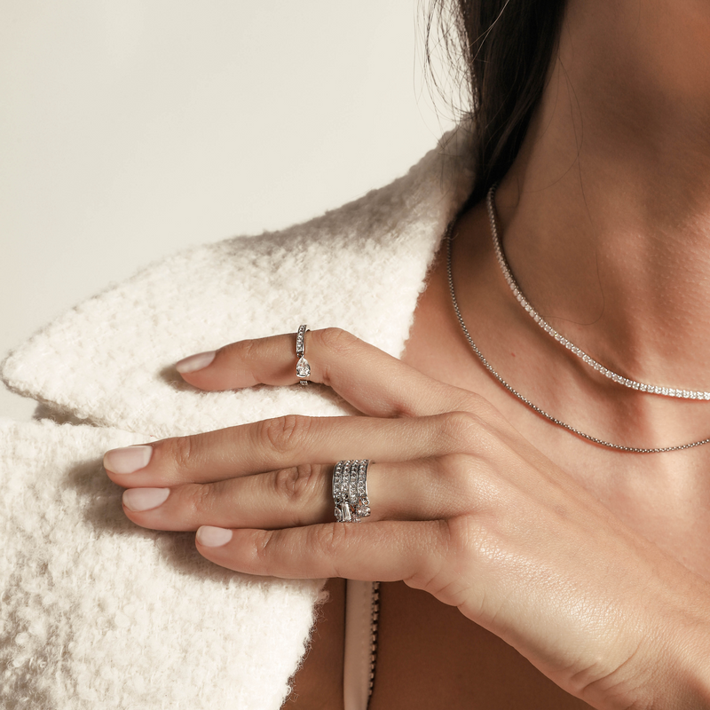 Model wearing two rings and the TENNIS DAINTY NECKLACE SET which includes 14" and 16" necklaces. One is Stainless steel Rhodium plated chain, 1mm Wide and the shorter one is a Rhodium-plated brass/cubic zirconia tennis necklace, 2 mm wide.