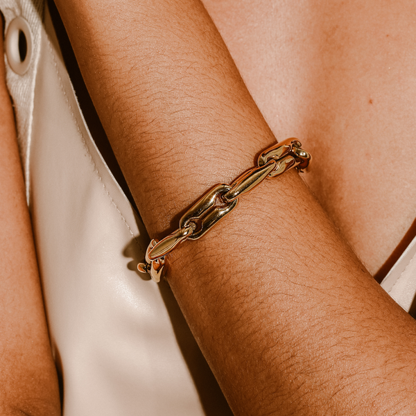 The MERGED BRACELET which is made of 18k gold plated stainless steel. It comes with large individual chains and has a total length of 7.5 inches.