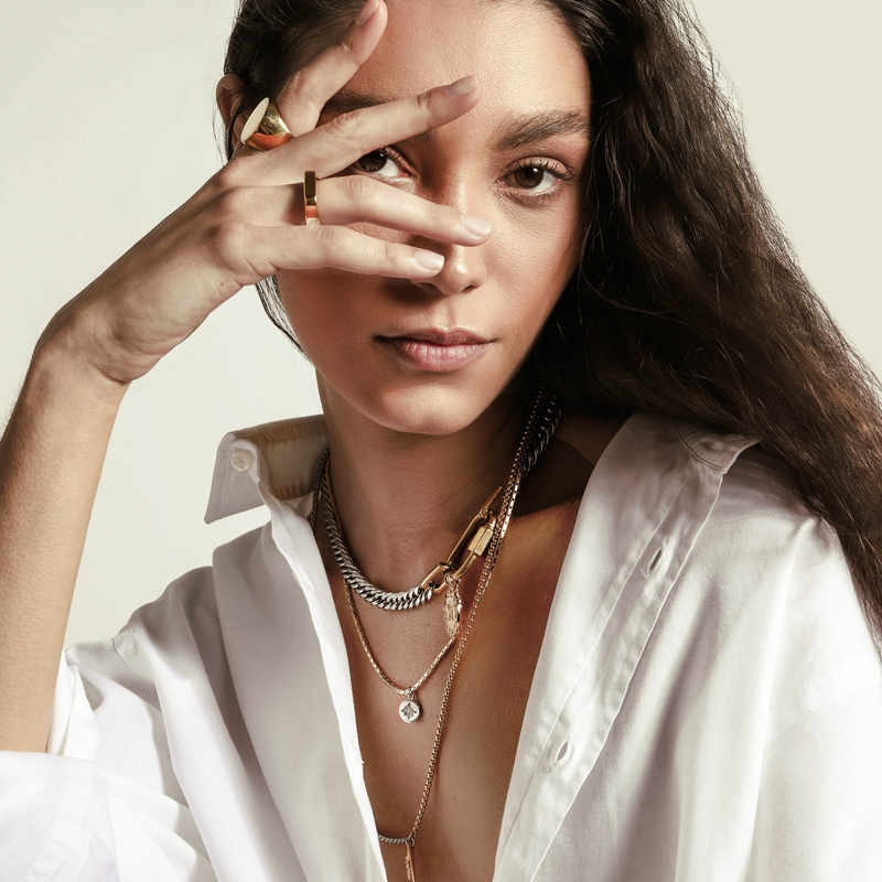 Model wearing the Amelia Layered Necklace set, rectangle ring and The SOLO GOLD RING which is made of an 18k Gold plated Stainless steel. It's an oversized flat oval shaped ring.