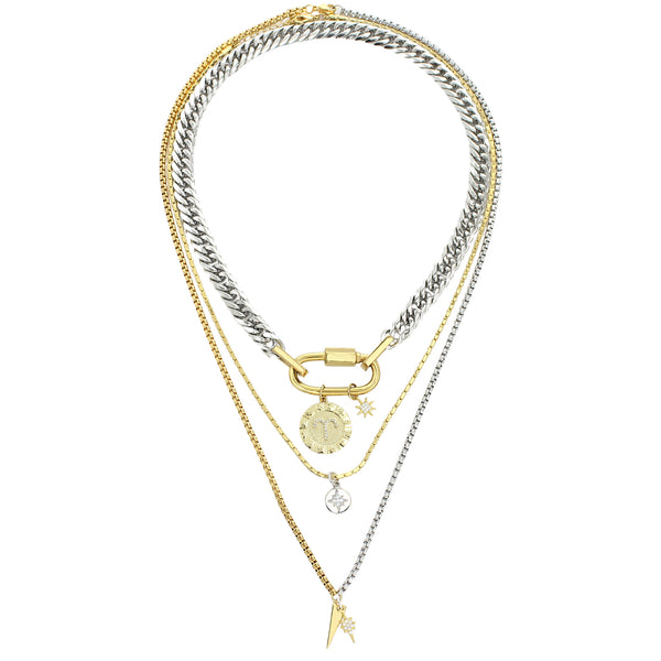 The Anne Zodiac Necklace which is a three pieces layered necklace set. Includes one silver chain with 18k gold plated carabiner and Gold Filled Aries Zodiac with Micro Pave Constellation charm, thin gold necklace with silver circle charm and another long necklace in half gold and silver with spike shaped charm and Gold Plated Micro Pave Studded Star.