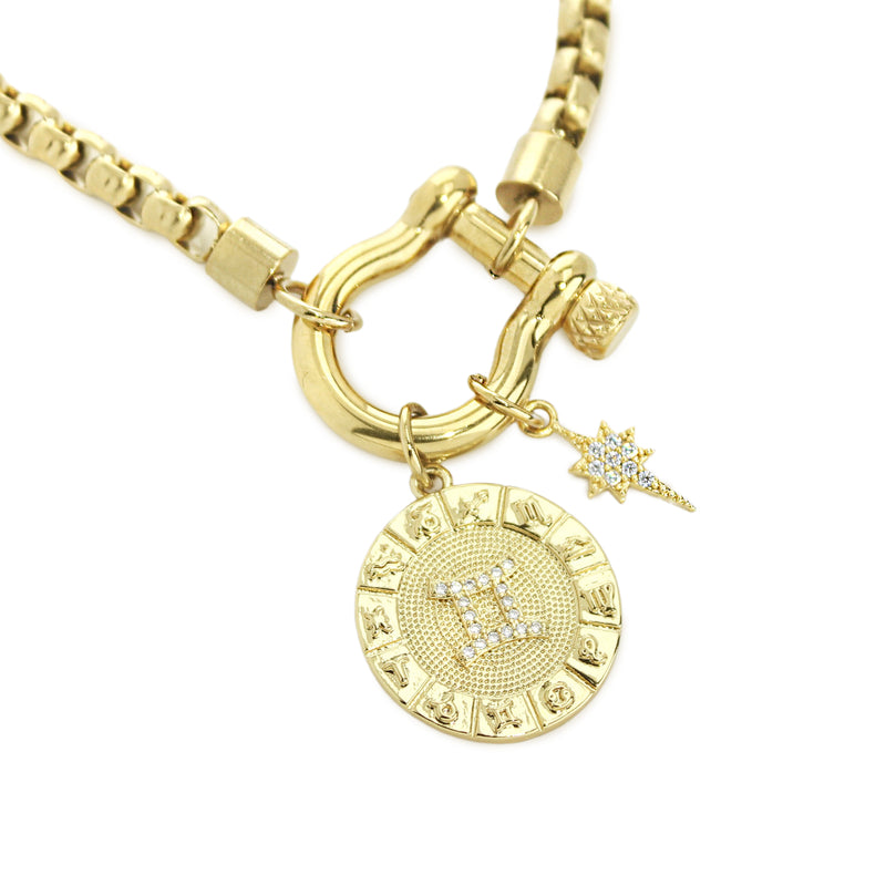 The Gemini Herradura Zodiac Necklace which is made of 18” Hypoallergenic Gold Plated Stainless Steel chain with 18K Gold Plated Horseshoe clasp and miniature star pendant and circular star sign micro pave Gemini constellation charm.