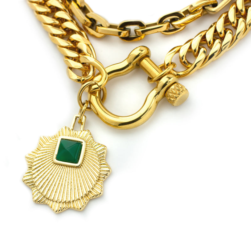 The EMERALD HERRADURA which is a 2 layered chain set comes with 18k Gold plated stainless steel chunky chain with gold horseshoe clasp and another thin chain with the Zirconia evil eye charm and a man-made 18k gold plated emerald pendant disc.