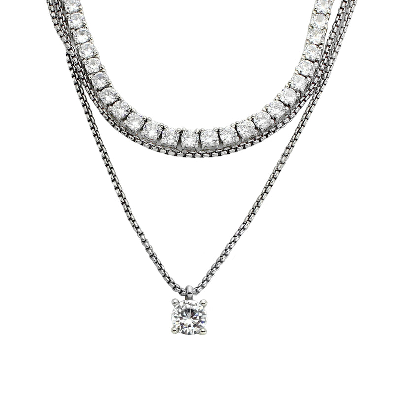 The TENNIS NECKLACE SET which includes three layered necklaces. One is a 1mm wide, Stainless steel Rhodium plated chain, a Rhodium-plated brass/cubic zirconia tennis necklace and 18" necklace with a Solitaire 1 ct zirconia pendant. 