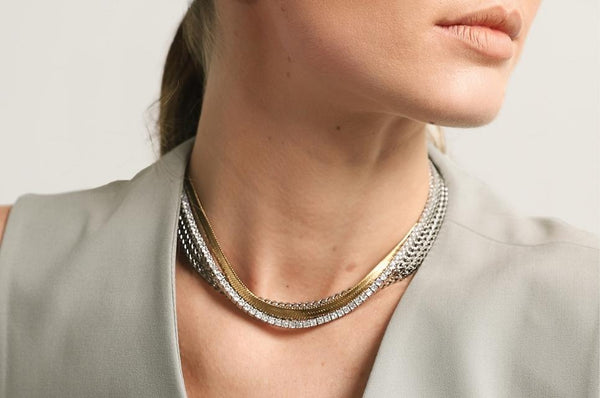 Woman's neck featuring silver and gold Artizan Necklaces.