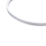 The DUST BANGLE, which is a single silver bracelet, features a refined and polished design highlighted by a sparkling row of stones along its sleek band. This elegant piece is perfect for wearing alone or stacking with other bracelets for a sophisticated, versatile style. ||| SILVER