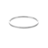 The DUST BANGLE, which is a single silver bracelet, features a refined and polished design highlighted by a sparkling row of stones along its sleek band. This elegant piece is perfect for wearing alone or stacking with other bracelets for a sophisticated, versatile style. ||| SILVER