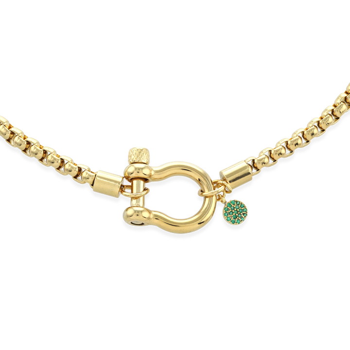 The Herradura Green Necklace, a single gold chain necklace featuring a bold clasp and a small green charm. This sleek and modern piece adds a touch of color and elegance, perfect for layering or wearing alone as a statement accessory.