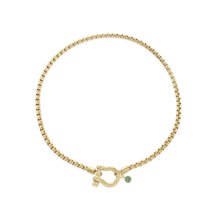 The Herradura Green Necklace, a single gold chain necklace featuring a bold clasp and a small green charm. This sleek and modern piece adds a touch of color and elegance, perfect for layering or wearing alone as a statement accessory.