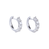 The Main Hoop, which is a pair of silver-tone hoop earrings featuring a row of dazzling round-cut stones along the front, offering a statement design that combines elegance and brilliance for any occasion.