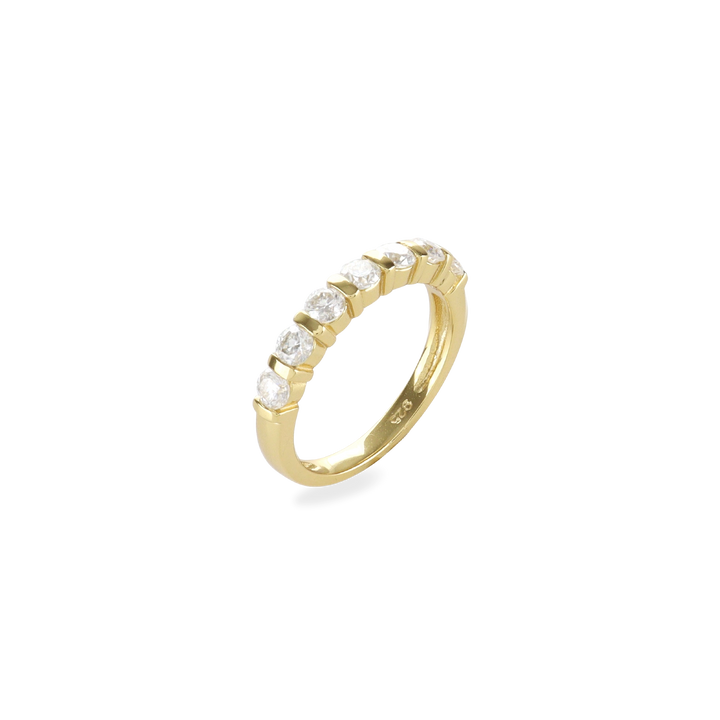 The Diamond Crown Half Band Ring which is a stunning single-piece ring crafted in gold, featuring a row of seven sparkling diamond-like stones set elegantly along the band. This piece combines timeless sophistication with modern luxury, perfect for adding a touch of brilliance to any outfit.