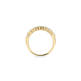 The Diamond Crown Half Band Ring which is a stunning single-piece ring crafted in gold, featuring a row of seven sparkling diamond-like stones set elegantly along the band. This piece combines timeless sophistication with modern luxury, perfect for adding a touch of brilliance to any outfit.