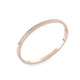 The DUST BANGLE, which is a single rose gold bracelet, features a sleek and elegant design adorned with a delicate row of shimmering stones along its band. This sophisticated piece adds a subtle sparkle, perfect for stacking or wearing solo for a refined touch. ||| ROSE GOLD