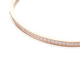 The DUST BANGLE, which is a single rose gold bracelet, features a sleek and elegant design adorned with a delicate row of shimmering stones along its band. This sophisticated piece adds a subtle sparkle, perfect for stacking or wearing solo for a refined touch. ||| ROSE GOLD