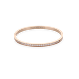 The DUST BANGLE, which is a single rose gold bracelet, features a sleek and elegant design adorned with a delicate row of shimmering stones along its band. This sophisticated piece adds a subtle sparkle, perfect for stacking or wearing solo for a refined touch. ||| ROSE GOLD