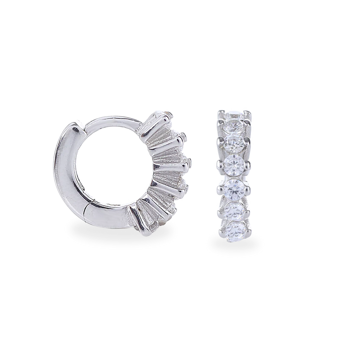 The Tiny Huggies Hoop, a pair of small silver hoop earrings that feature a row of sparkling cubic zirconia stones set in a  pointed, triangular pattern.||| SILVER