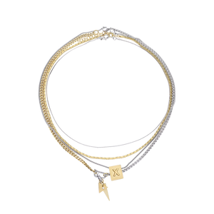 The Letter Necklace Set, which is a three-piece layered necklace set, features a combination of gold and silver chains with two unique charms—a square charm engraved with a letter 'X' and a small lightning bolt pendant.