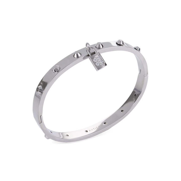 The Lock Bangle, which is a single silver bangle, features a studded design with a sparkling lock charm. This sleek piece in silver adds a refined, edgy touch with its distinctive lock detail, making it a versatile statement accessory on its own. ||| SILVER
