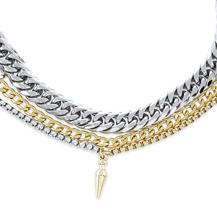 The Mulato Set, which is a four-piece layered necklace set, combines bold gold and silver chains with distinct textures and a drop pendant, offering a striking blend of modern elegance and statement-making versatility.