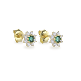 The Emerald Flower Stud Earrings, a pair of elegant gold earrings featuring a central green emerald surrounded by petal-like sparkling white stones in a floral design. These dainty stud earrings add a touch of sophistication and timeless beauty, perfect for any occasion.