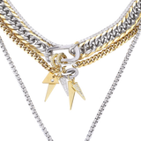 The Triangle Necklace Set, a three-piece necklace set with gold and silver chains, including a cuban link, a box chain, and a tennis chain with triangle spike charms.