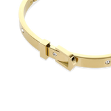 The BELT BANGLE, a stylish gold bangle featuring a unique buckle clasp design with sparkling diamond accents. ||| GOLD