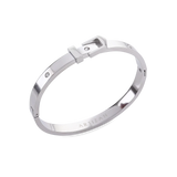 The BELT BANGLE, a stylish silver bangle featuring a unique buckle clasp design with sparkling diamond accents. ||| SILVER