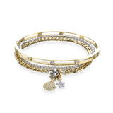 The Golden Gear Bracelet Stack, a three-piece gold bracelet stack featuring a bangle with diamond-like accents, a diamond-like tennis bracelet, and a chain bracelet with two charms.