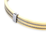 The MARINERO BANGLE, which is a single gold-tone bracelet, features sleek, parallel silver wires along its top surface, creating a refined two-tone nautical-inspired design. This elegant piece by Artizan adds a sophisticated touch with its polished finish and sturdy construction, ideal for daily wear or special occasions. ||| GOLD