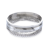 The Silver Gear Bracelet Stack, a five piece silver bracelet stack includes three unique bangle styles, one featuring a row of sparkling stones and another with a sleek, minimalist design. Two delicate tennis bracelets with shimmering stones.