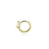 The One Stone Gold Piercing Hoops, which is a gold hoop earring, feature a central heart-shaped stone with additional sparkling accents along the band.
