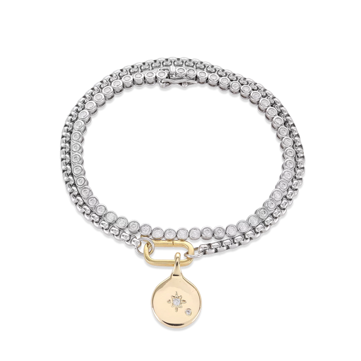 The Tennis and the Box Bracelet Set, a two-piece silver bracelet set featuring a diamond-like tennis bracelet and a box chain bracelet with a gold north star charm accented with diamond-like stones.