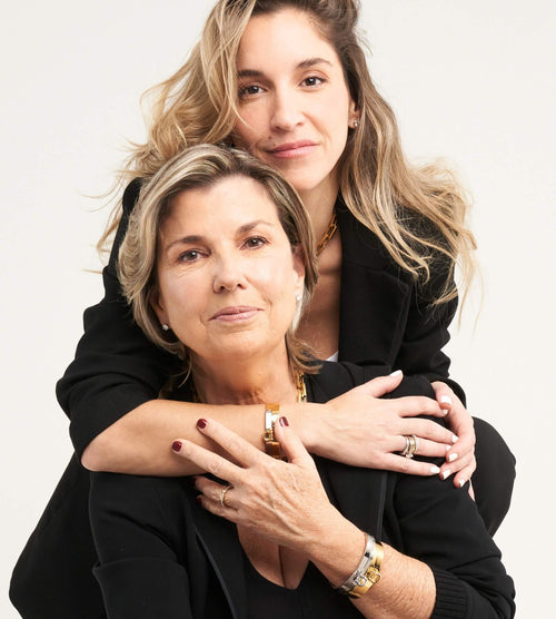 A mother and daughter wearing Artizan Joyeria jewelry, featuring gold and silver bracelets and rings, styled in matching black outfits.






