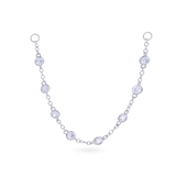 The Endless Diamond Earring Chain, a gold chain featuring seven bezel-set diamond-like stones. She is also earing a tiny lightning stud earring