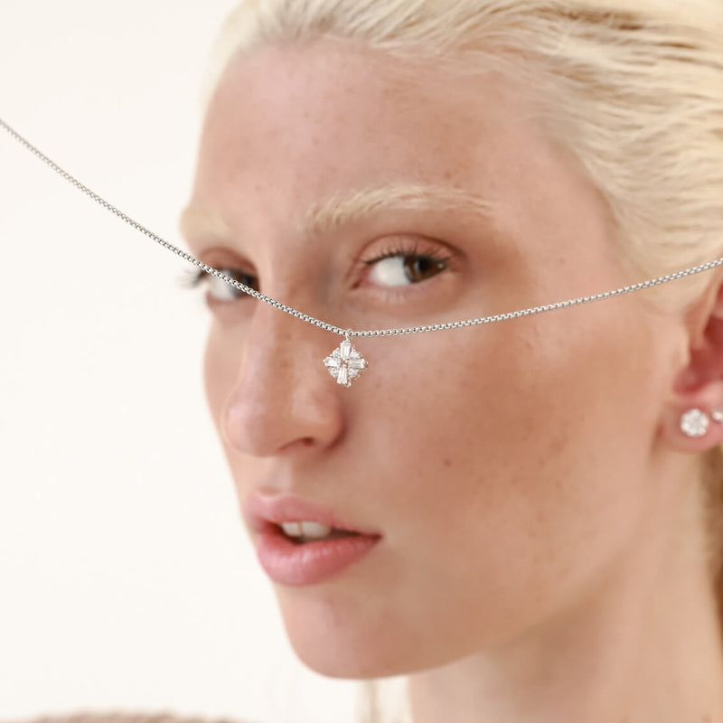 Model looking at the RHOMBUS ZIRCONIA NECKLACE which is made of 1mm wide Stainless steel chain with 18K gold plated sterling silver rhombus zirconia charm.