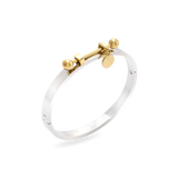 The Coin Bangle is a mixed-metal bracelet featuring a sleek silver band with gold-tone hardware, including a dangling coin charm and bold spherical accents. ||| MIX GOLD