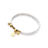 The Coin Bangle is a mixed-metal bracelet featuring a sleek silver band with gold-tone hardware, including a dangling coin charm and bold spherical accents. ||| MIX GOLD