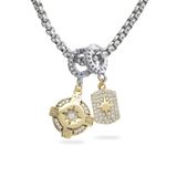 Silver chain with the Celestial Star Clip On Charm, which is a gold pavé star pendant, and the Go North Clip On Charm, which is a gold compass design, both attached to a silver chain.