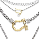The Herradura Signature Charmed Tennis Set, a layered necklace stack featuring a gold and silver Herradura pendant, a pavé tennis chain, and a delicate charm with a sparkling star detail.