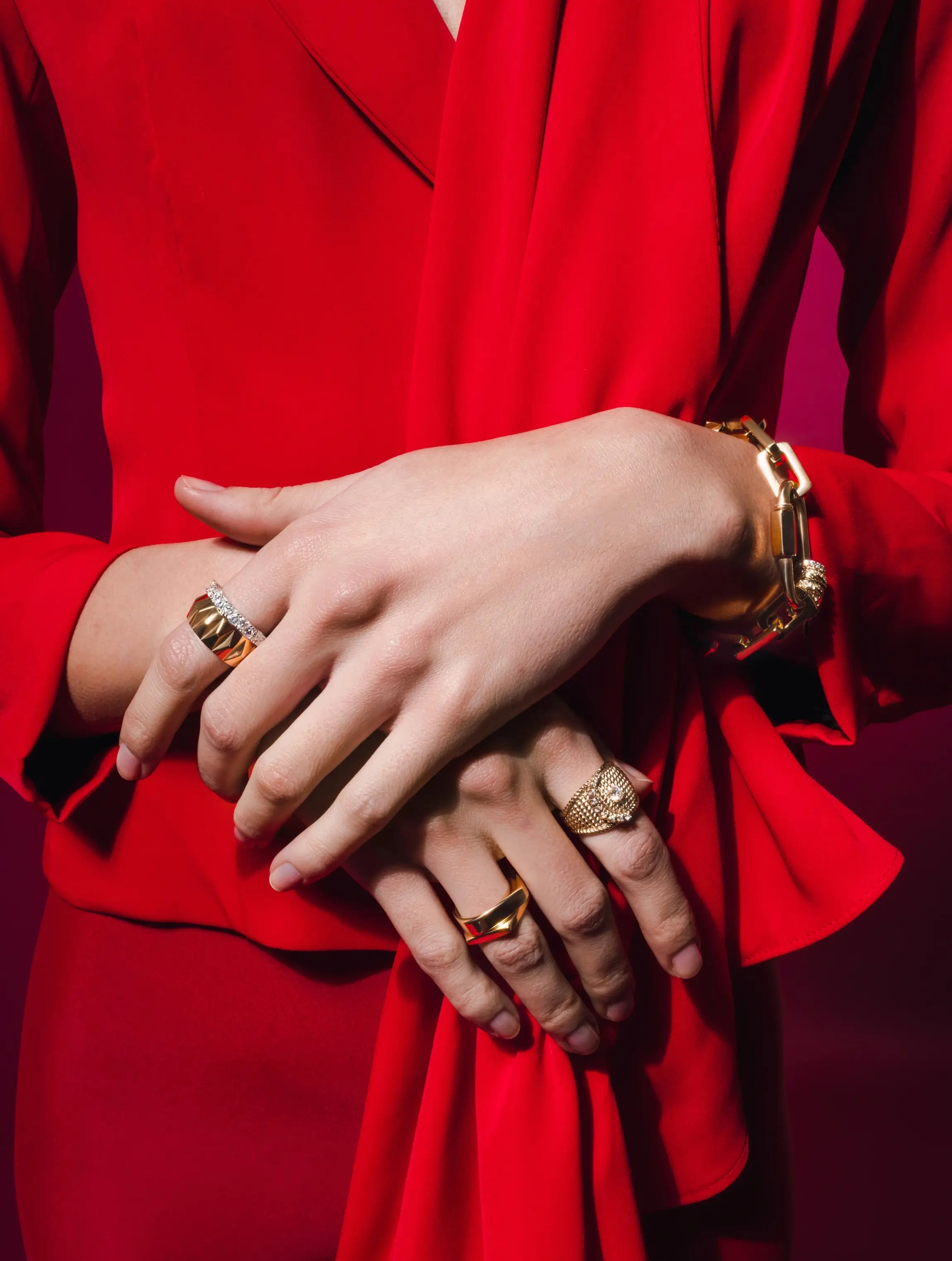 Model wearing a red dress and multiple Artizan Joyeria rings and square puerto bbracelet..