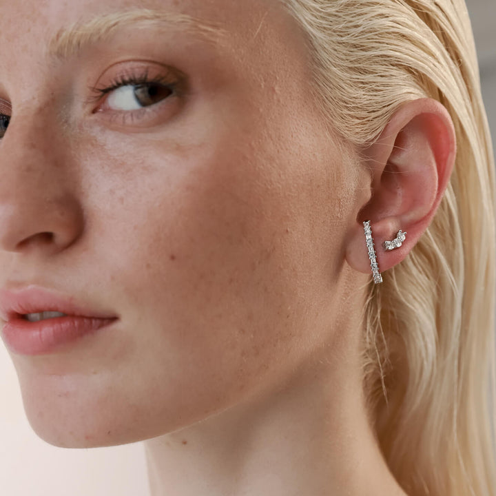 Model wearing the Comet's Trail Ear Stud made of sterling silver zirconia filled stud and a smaller three zirconia stud earrings.
