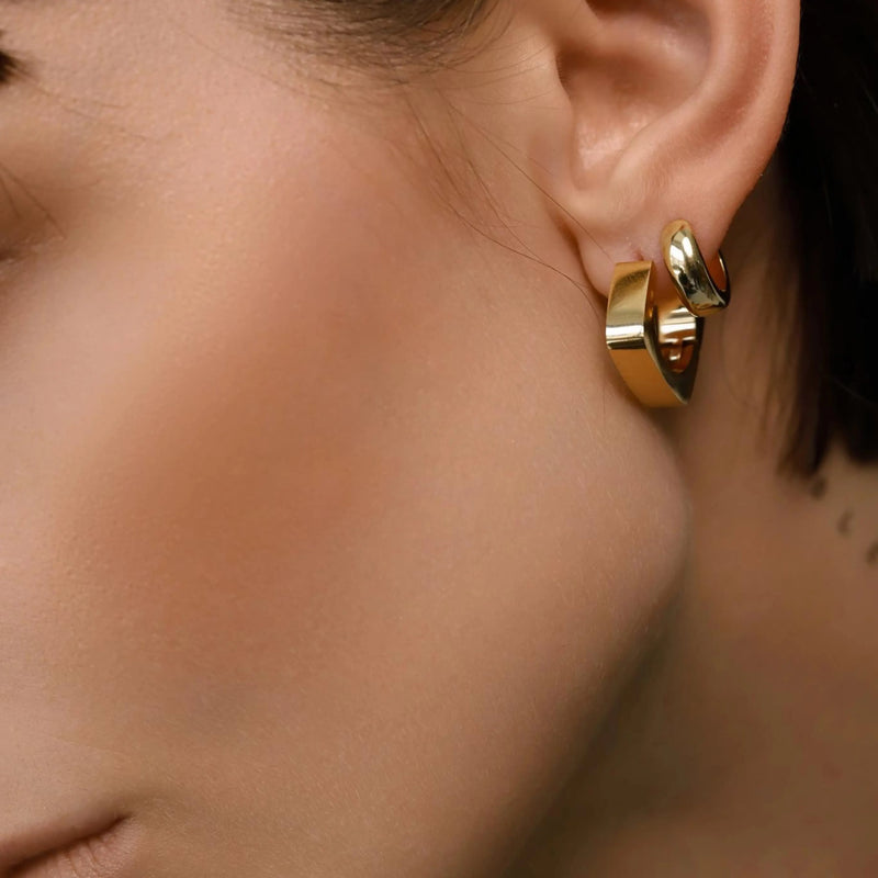 Model wearing the SHAPE HOOP earring that is 17mm x 17mm in size and made of Stainless steel 18k gold plated.
