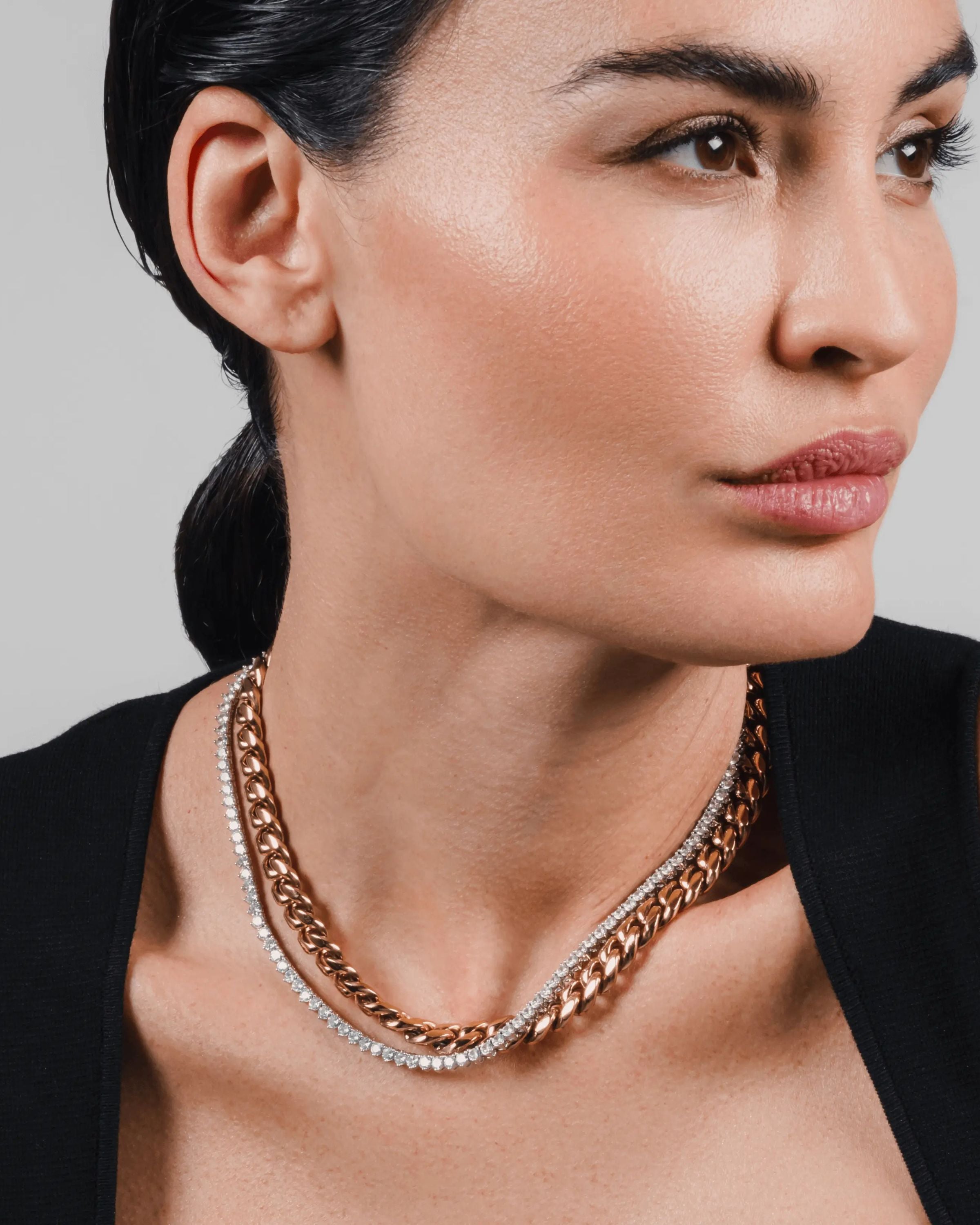 The TENNIS AND THE CURB CHAIN LAYERED NECKLACE SET which is a two-piece layered necklace stack featuring a gold curb chain and a silver tennis chain. ||| GOLD