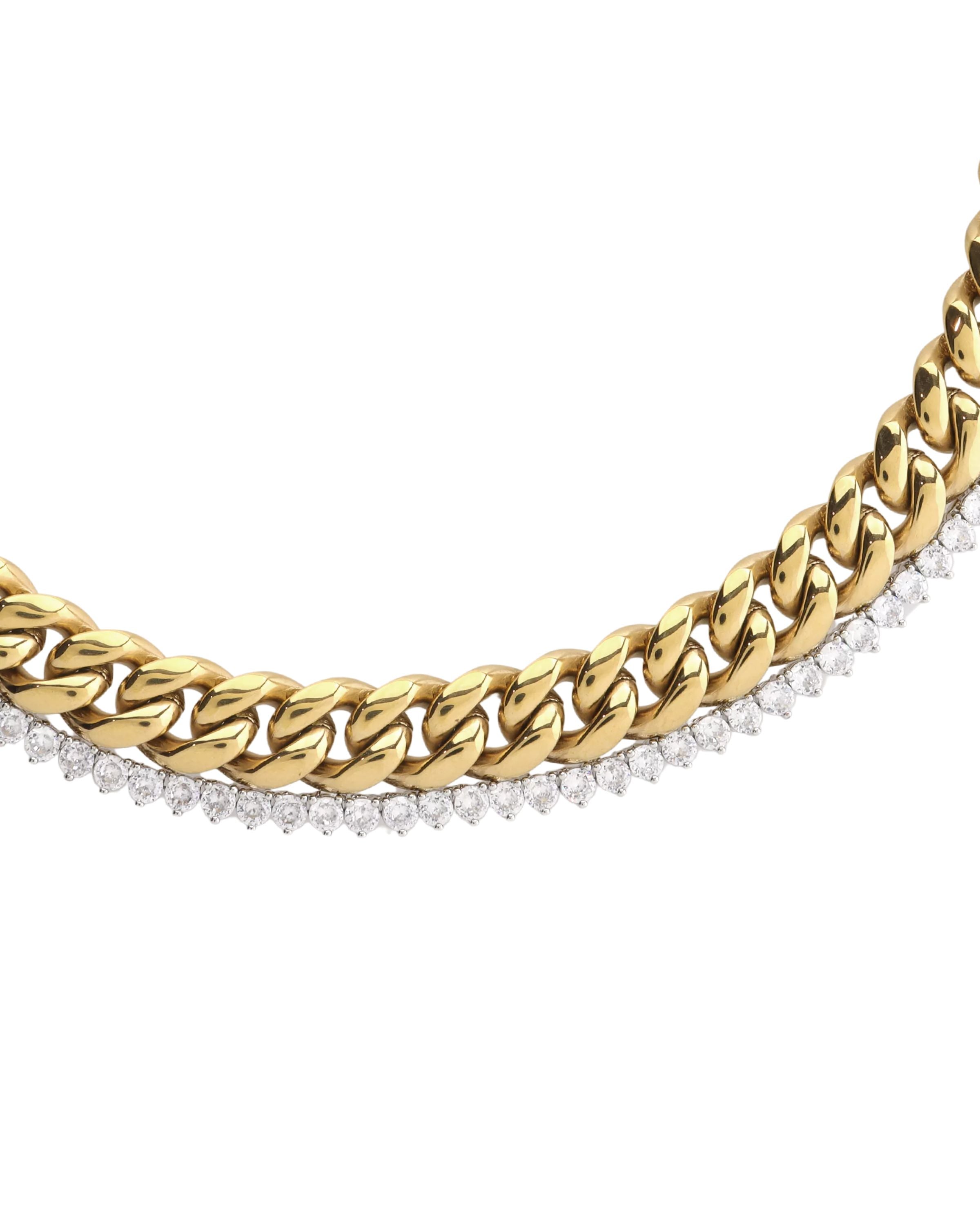 Close-up of The TENNIS AND THE CURB CHAIN LAYERED NECKLACE SET which is a two-piece layered necklace stack in gold, featuring a chunky curb chain and a diamond-accented tennis chain. ||| GOLD