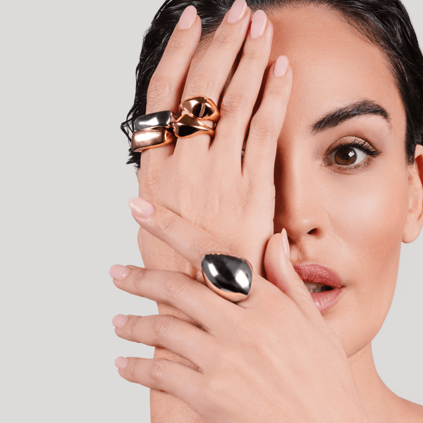 Model wearing the HIGH PEAK RING SET and the Fierce Ring in polished gold, featuring a bold and curvy design that exudes confidence and modern elegance. |||