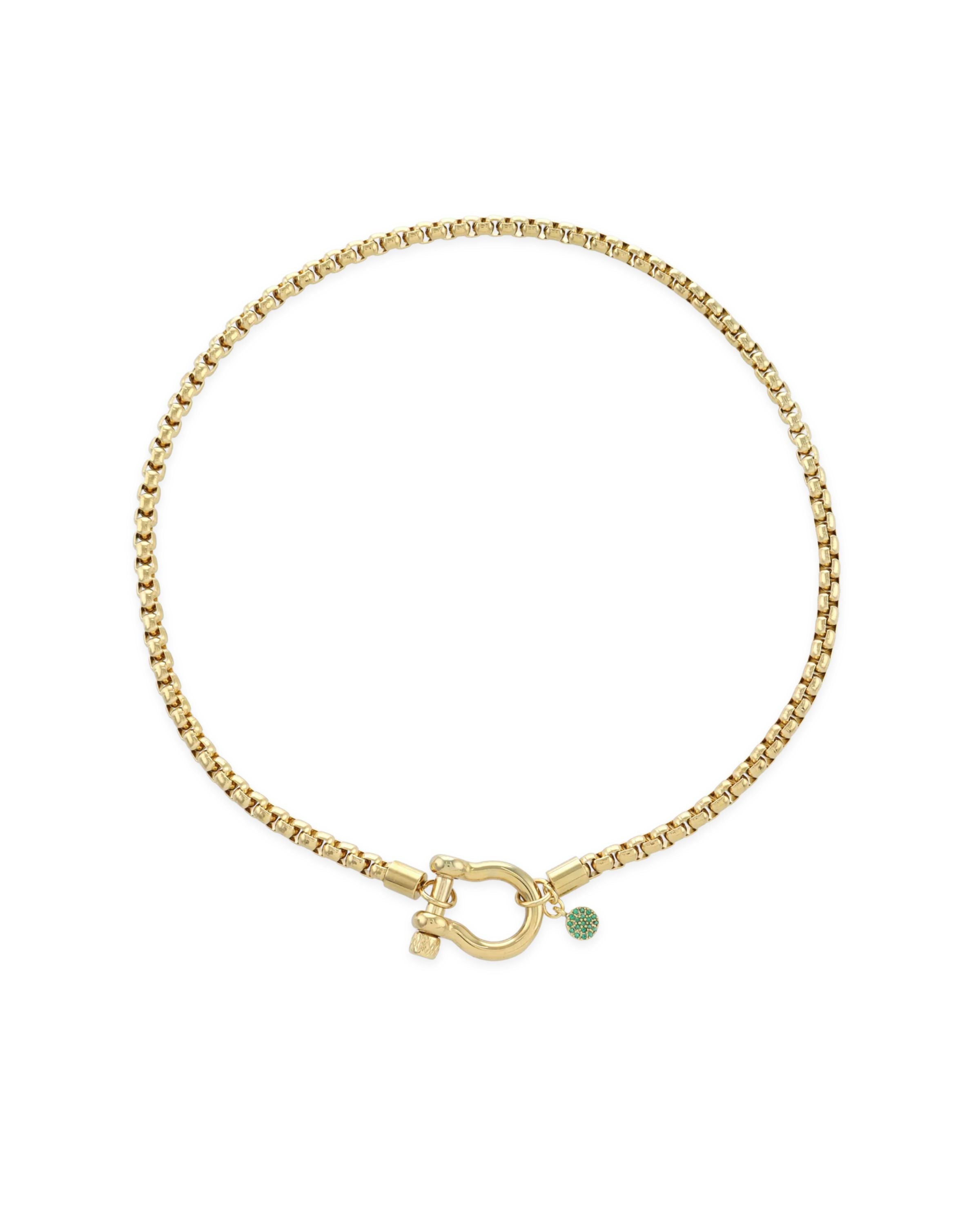 The Herradura Green Necklace, a single gold chain necklace featuring a bold clasp and a small green charm. This sleek and modern piece adds a touch of color and elegance, perfect for layering or wearing alone as a statement accessory.